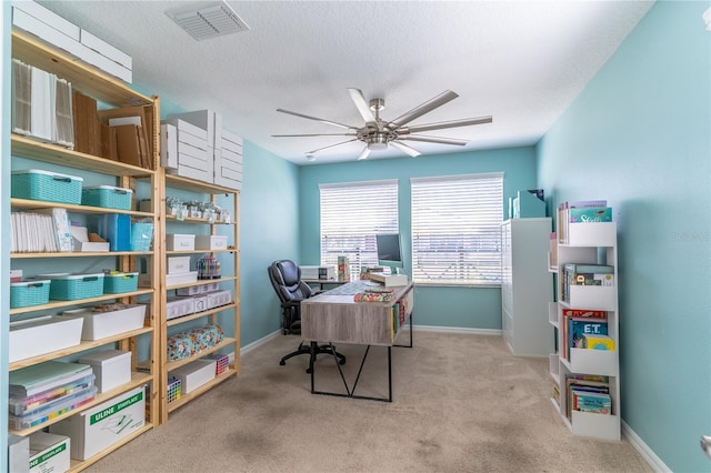 carpeted home office featuring ceiling fan and baseboards