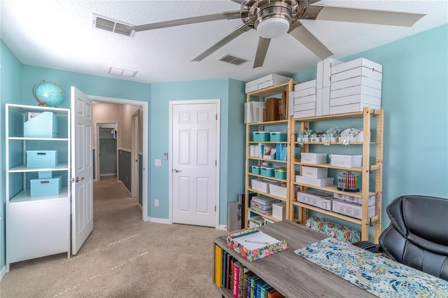 carpeted office featuring a ceiling fan, baseboards, and a textured ceiling