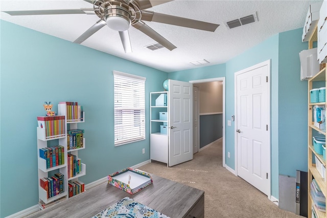 office area with a ceiling fan, baseboards, a textured ceiling, and carpet floors