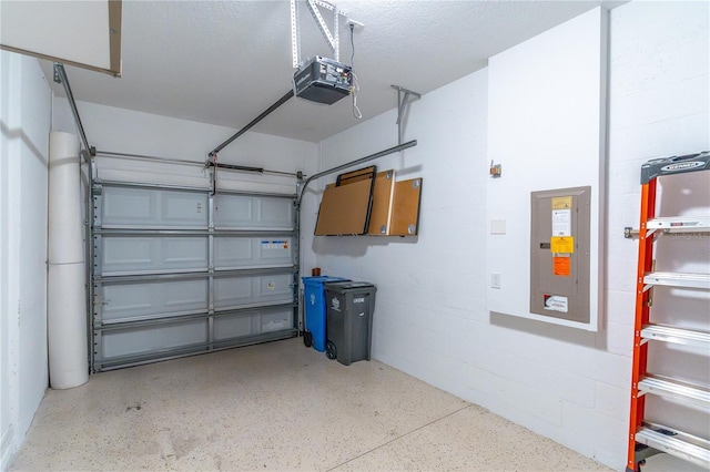 garage featuring a garage door opener, electric panel, and concrete block wall
