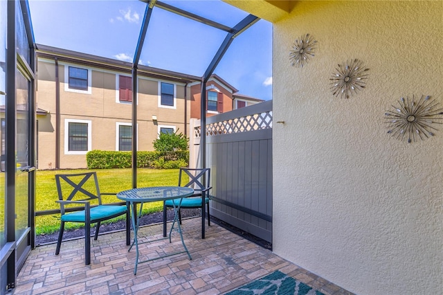 view of patio featuring glass enclosure