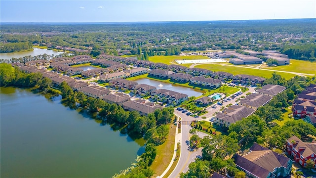 aerial view of property and surrounding area with a large body of water and nearby suburban area