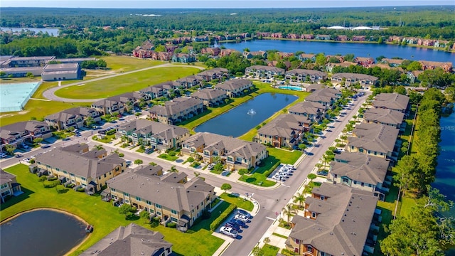 aerial perspective of suburban area featuring a large body of water and a heavily wooded area