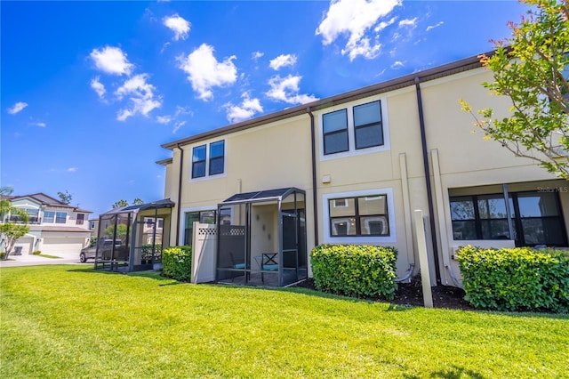 back of property featuring stucco siding and a yard