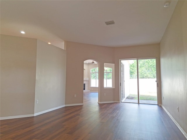 19855 Ellendale Dr, Land O Lakes, FL 34638 - empty room with dark wood finished floors, arched walkways, baseboards, and recessed lighting