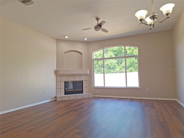 19855 Ellendale Dr, Land O Lakes, FL 34638 - unfurnished living room featuring dark wood-style flooring, a chandelier, baseboards, and a textured ceiling