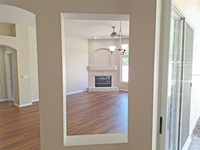 19855 Ellendale Dr, Land O Lakes, FL 34638 - unfurnished living room with wood finished floors, arched walkways, baseboards, and a chandelier