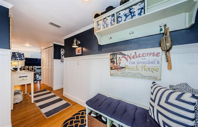 8210 Aquila St Unit 218, Port Richey, FL 34668 - mudroom with wainscoting, wood finished floors, a textured ceiling, and crown molding