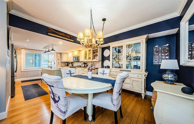 8210 Aquila St Unit 218, Port Richey, FL 34668 - dining space featuring a chandelier, baseboards, wood finished floors, and crown molding
