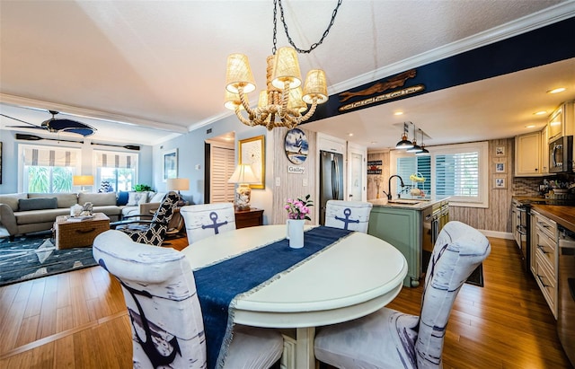 8210 Aquila St Unit 218, Port Richey, FL 34668 - dining space with a chandelier, ornamental molding, wood finished floors, plenty of natural light, and ceiling fan
