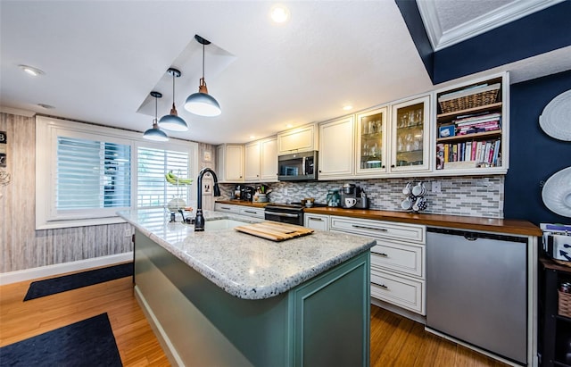 8210 Aquila St Unit 218, Port Richey, FL 34668 - kitchen with appliances with stainless steel finishes, a sink, butcher block counters, wood finished floors, and decorative backsplash