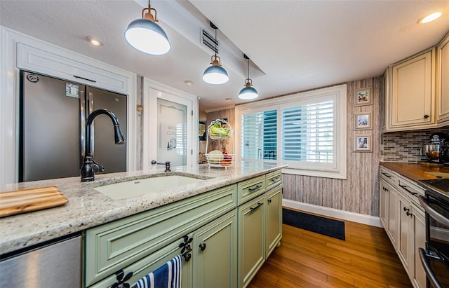 8210 Aquila St Unit 218, Port Richey, FL 34668 - kitchen featuring green cabinetry, baseboards, wood finished floors, and decorative light fixtures