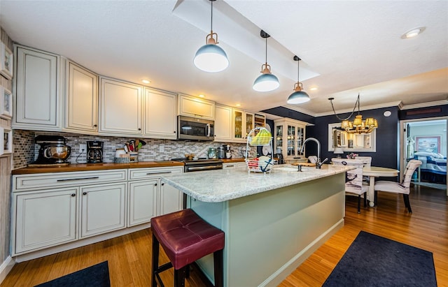 8210 Aquila St Unit 218, Port Richey, FL 34668 - kitchen featuring stainless steel microwave, tasteful backsplash, range with electric stovetop, light wood-type flooring, and ornamental molding