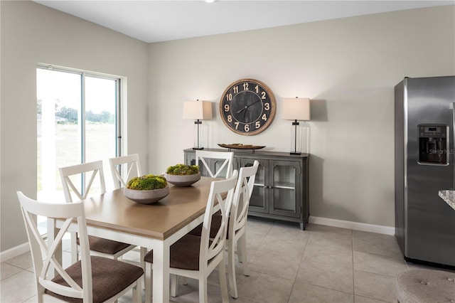 dining room featuring baseboards and light tile patterned flooring