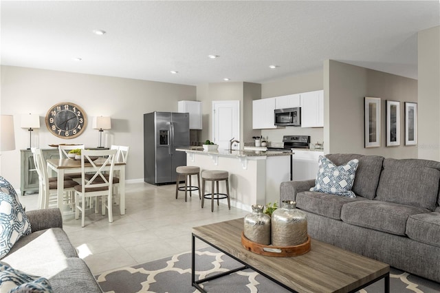 living area featuring light tile patterned flooring, baseboards, and recessed lighting