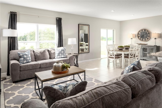 living area featuring baseboards and light tile patterned floors