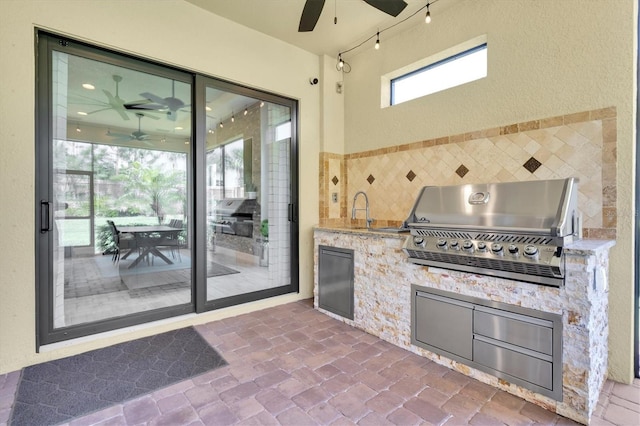 view of patio with grilling area, an outdoor kitchen, and a ceiling fan