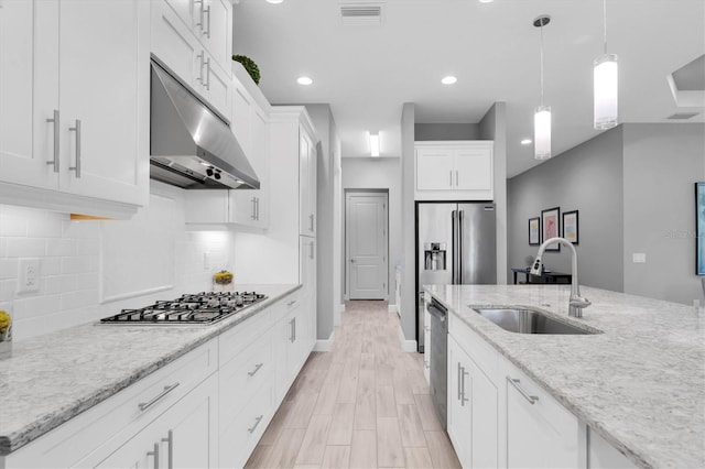 kitchen featuring visible vents, a sink, white cabinets, under cabinet range hood, and stainless steel appliances