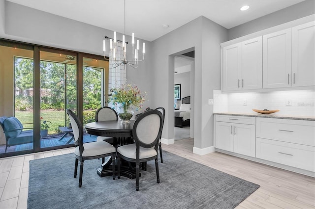 dining room featuring light wood-type flooring, recessed lighting, baseboards, and a chandelier
