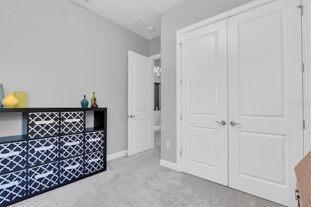 carpeted bedroom with a closet and baseboards