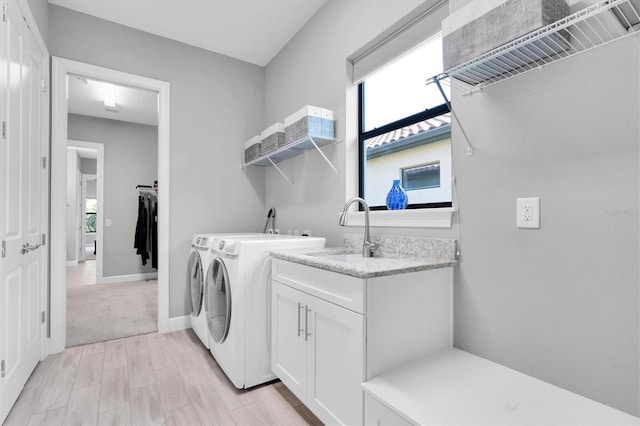 laundry area featuring a sink, separate washer and dryer, plenty of natural light, and cabinet space