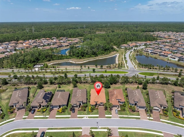 bird's eye view featuring a residential view, a water view, and a wooded view
