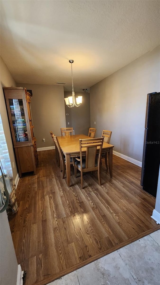 9007 49th Ave E, Palmetto, FL 34221 - dining area with baseboards, a chandelier, and wood finished floors