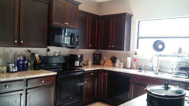 9007 49th Ave E, Palmetto, FL 34221 - kitchen with black appliances, a sink, light stone countertops, and dark brown cabinetry
