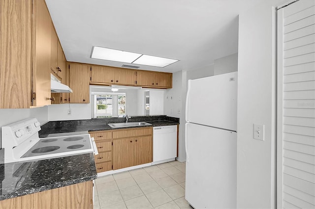 kitchen featuring a sink, dark stone counters, under cabinet range hood, and white appliances