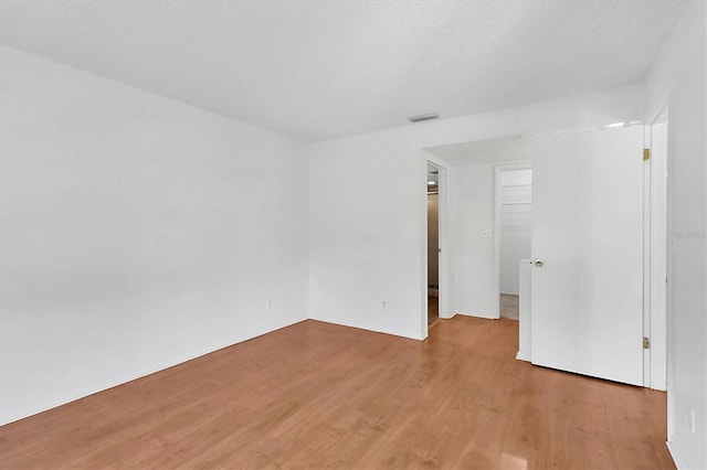 unfurnished room with light wood-style flooring and visible vents
