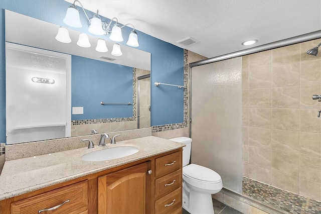 bathroom with visible vents, vanity, toilet, and a shower stall