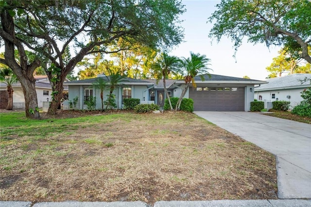 ranch-style house with a garage, stucco siding, and driveway