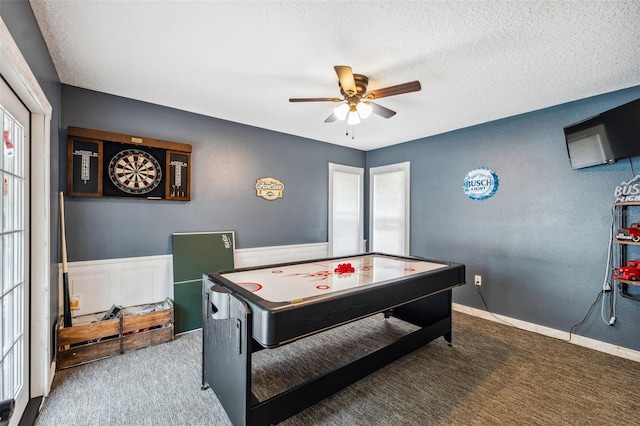 playroom featuring ceiling fan, carpet, and a textured ceiling