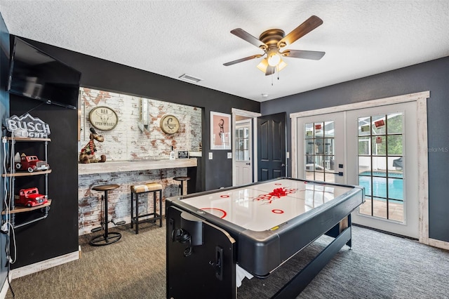 rec room with carpet floors, a textured ceiling, a ceiling fan, french doors, and baseboards