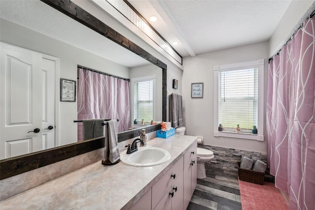 bathroom with wood finished floors, toilet, vanity, a textured ceiling, and recessed lighting