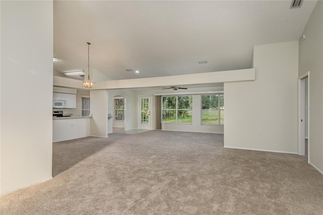 unfurnished living room featuring light colored carpet, arched walkways, ceiling fan with notable chandelier, recessed lighting, and baseboards