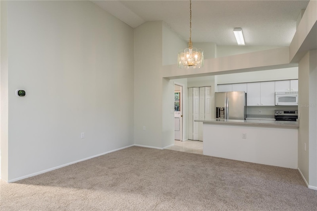 unfurnished living room with a notable chandelier, light colored carpet, washer / clothes dryer, baseboards, and lofted ceiling