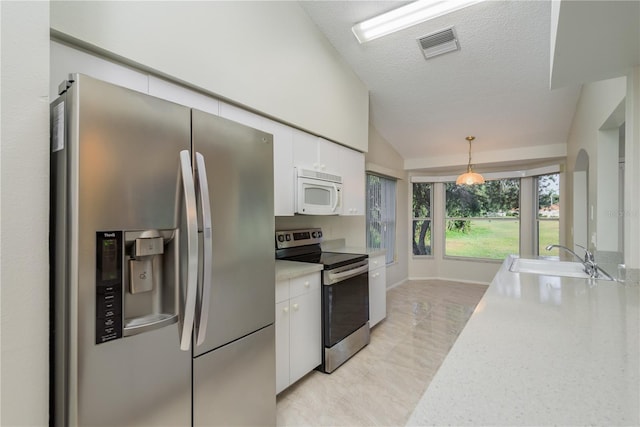 kitchen featuring a sink, light countertops, stainless steel appliances, white cabinetry, and visible vents