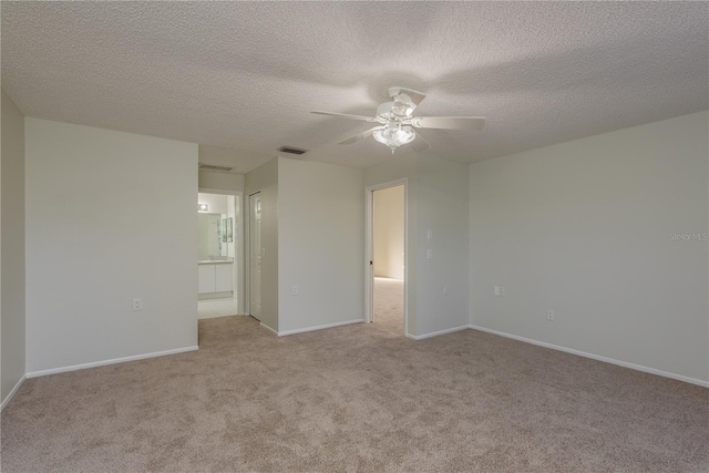 spare room with carpet floors, a ceiling fan, a textured ceiling, and visible vents