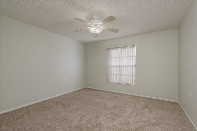 spare room with baseboards, ceiling fan, carpet, and a textured ceiling