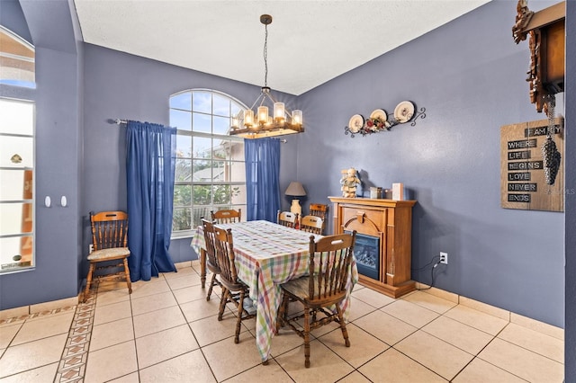 12040 Penzance Ln, New Port Richey, FL 34654 - dining room with a glass covered fireplace, a notable chandelier, and light tile patterned flooring