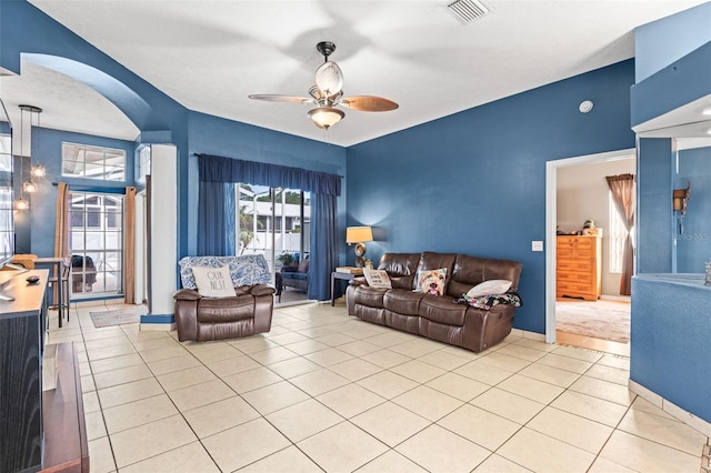 12040 Penzance Ln, New Port Richey, FL 34654 - living room with a ceiling fan, arched walkways, light tile patterned flooring, and baseboards