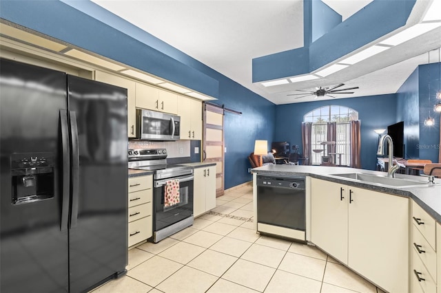 12040 Penzance Ln, New Port Richey, FL 34654 - kitchen with black appliances, a sink, dark countertops, light tile patterned flooring, and a skylight