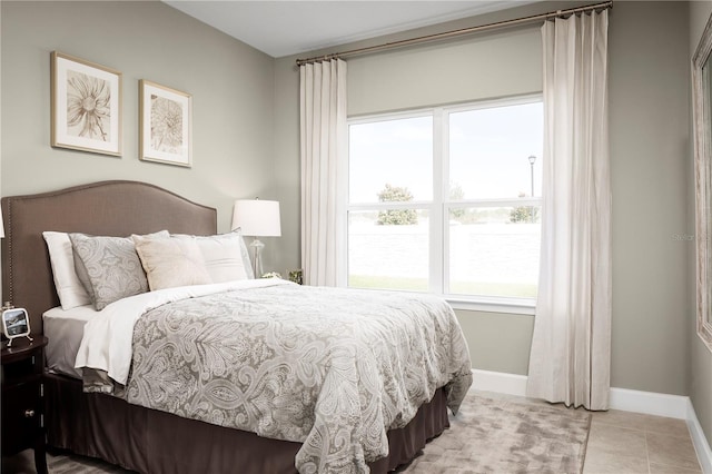 bedroom with baseboards and light tile patterned flooring