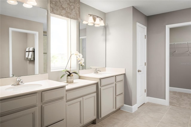 bathroom with baseboards, tile patterned floors, two vanities, and a sink