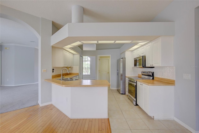 7827 Starfire Way, New Port Richey, FL 34654 - kitchen with stainless steel appliances, a sink, arched walkways, and tasteful backsplash