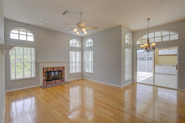 7827 Starfire Way, New Port Richey, FL 34654 - unfurnished living room with plenty of natural light, light wood-style floors, a ceiling fan, and a chandelier