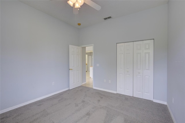 7827 Starfire Way, New Port Richey, FL 34654 - unfurnished bedroom with carpet flooring, baseboards, a closet, ceiling fan, and a high ceiling