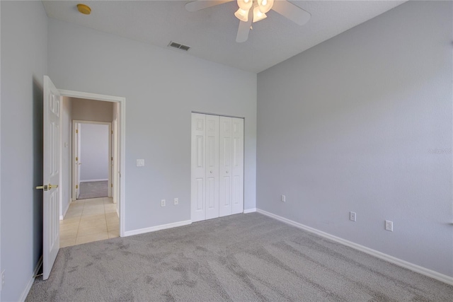 7827 Starfire Way, New Port Richey, FL 34654 - unfurnished bedroom with light carpet, baseboards, a closet, a ceiling fan, and light tile patterned floors