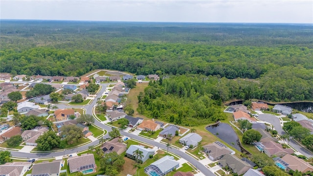 7827 Starfire Way, New Port Richey, FL 34654 - aerial overview of property's location with a heavily wooded area, nearby suburban area, and a nearby body of water
